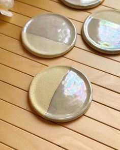 four white plates sitting on top of a wooden table covered in iridescents