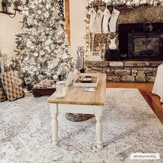 a living room filled with furniture and a christmas tree in front of a fire place