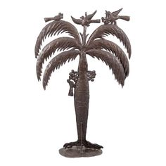 a metal palm tree with two birds on it's back and one bird perched on top