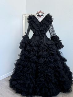 a black dress with ruffled layers and a crown on top