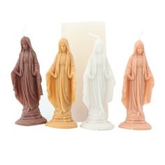 three candles with the image of mary and jesus in different colors, one is lit