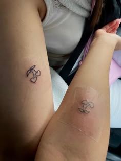 two people with matching tattoos on their arms