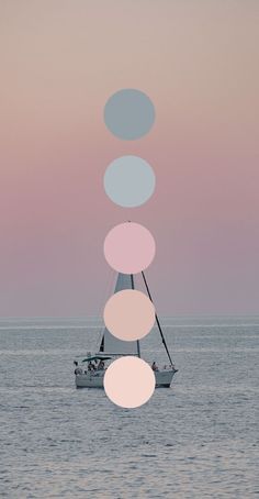 a sailboat floating in the ocean with four circles hanging from it's mast