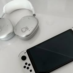 a nintendo wii game controller sitting next to an electronic device with headphones on it