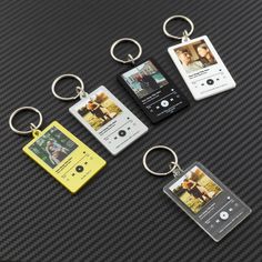 four different types of keychains are shown on a black surface with an ipod in the middle