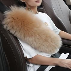 a woman sitting in the back seat of a car with a fur stole on her shoulder