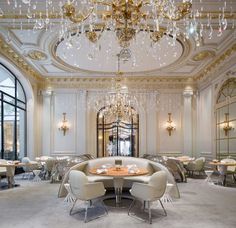 an elegant dining room with chandeliers and round tables