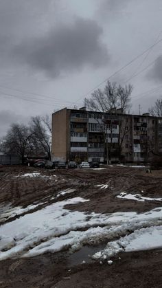 an abandoned building sits in the middle of a barren area with snow on the ground