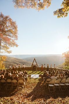 a group of people sitting in chairs on top of a hillside