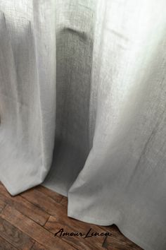 closeup of white curtains with wood flooring