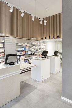 an empty pharmacy store with laptops on the counter and shelves full of medicine bottles