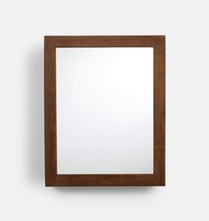 a square mirror mounted on the wall with a wooden frame and wood trim around it