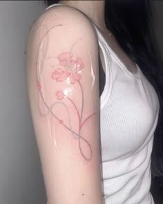 a woman with a tattoo on her arm that has pink flowers in the middle of it