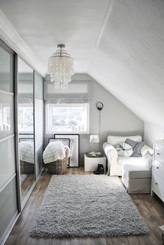 an attic bedroom with white furniture and gray carpeted flooring on the hardwood floors