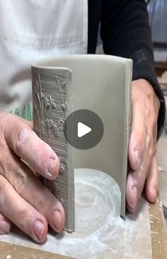 a person is working with clay on a piece of pottery in their hands and holding the block