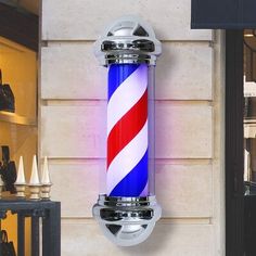 there is a blue and red striped light fixture on the side of a building,