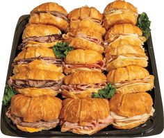 a tray filled with sandwiches and croissants on top of eachother