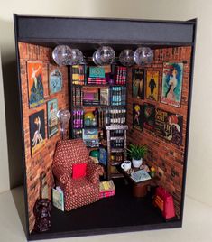 a doll house with furniture and bookshelves on the walls, in front of a brick wall