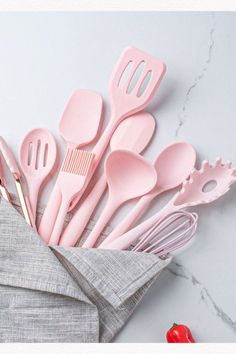 pink kitchen utensils are sitting in an envelope