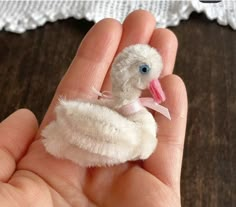 a small stuffed bird in someones hand