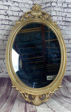 a mirror sitting on top of a wooden floor next to a brick wall and white bricks