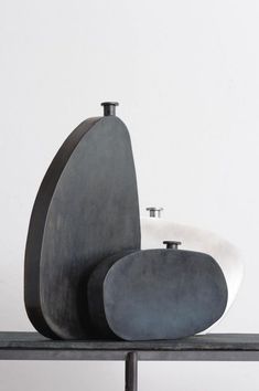 two sculptures sitting on top of a wooden table