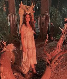 a woman standing in the middle of a forest with red light coming from her head