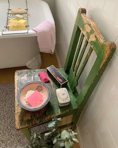 an old wooden chair sitting next to a bath tub filled with soap and other items