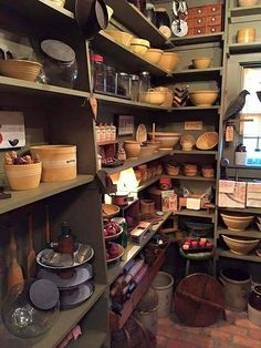 a room filled with lots of pots and pans on shelves next to each other