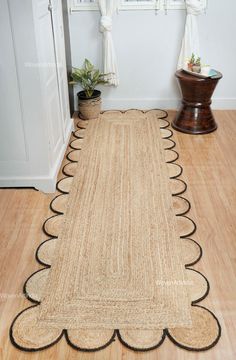 the rug is on the wooden floor by the window and potted plant next to it