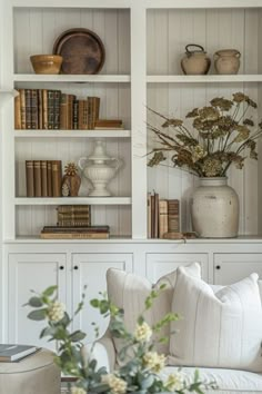 a living room filled with furniture and bookshelves covered in lots of white bookcases