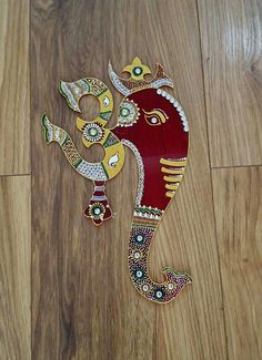 an intricately painted elephant on a wooden floor