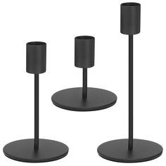 three black candlesticks and one candle holder