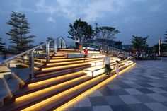 people are walking up and down the stairs with lights in their handrails at dusk