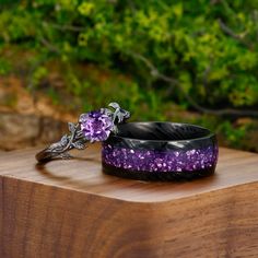 two purple and black bracelets sitting on top of a wooden table next to each other