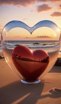 a heart shaped vase sitting on top of a sandy beach