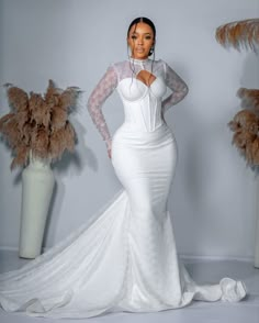 a woman in a white wedding dress posing for the camera with her hands on her hips