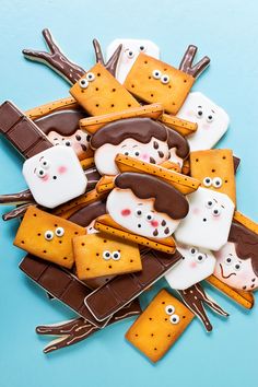 there are many cookies decorated like cats and dogs on the blue surface with chocolate sticks