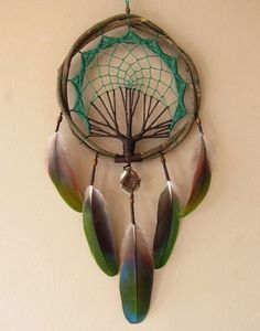 a dream catcher hanging on the wall with feathers