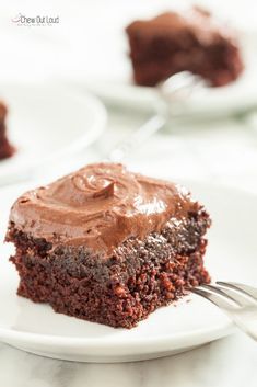 a piece of chocolate cake on a white plate with a bite taken out of it