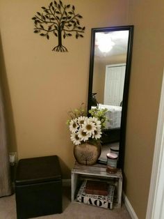 a vase with flowers sitting on top of a table next to a mirror