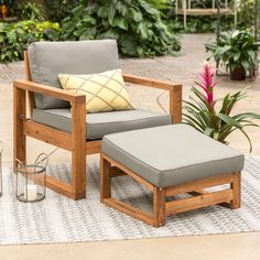 a chair and ottoman sitting on top of a rug in front of a garden area