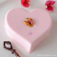 a pink heart shaped box sitting on top of a white plate