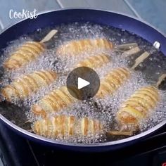 some food is cooking in a frying pan on the stove with water and oil