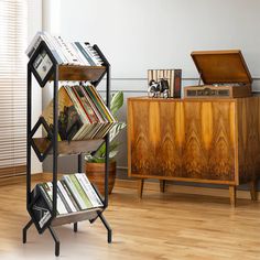 a book shelf with many books on it and a chest of drawers in the background