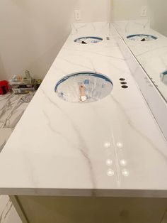 a bathroom counter with two sinks and mirrors