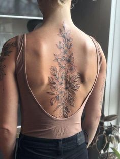 the back of a woman's neck with flowers on it