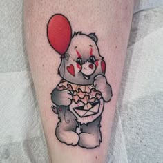 a small tattoo of a bear holding a heart balloon and eating pizza on the leg