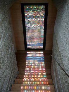 the light is shining through the window on the stairs in this building's entryway