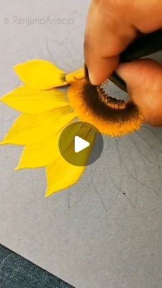 someone is painting a sunflower with yellow paint